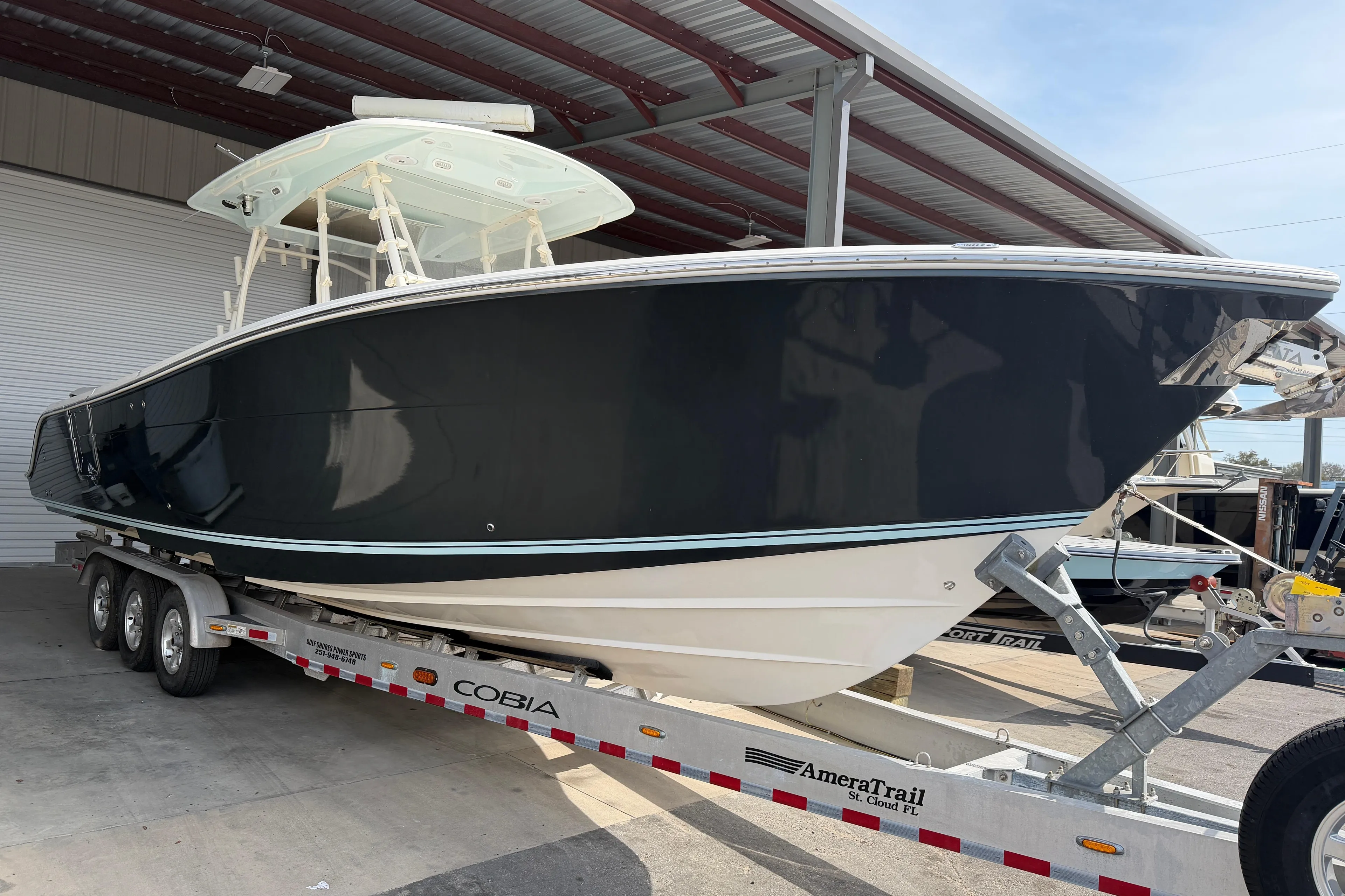 2015 Cobia 344 Center Console boat on trailer in covered storage area.
