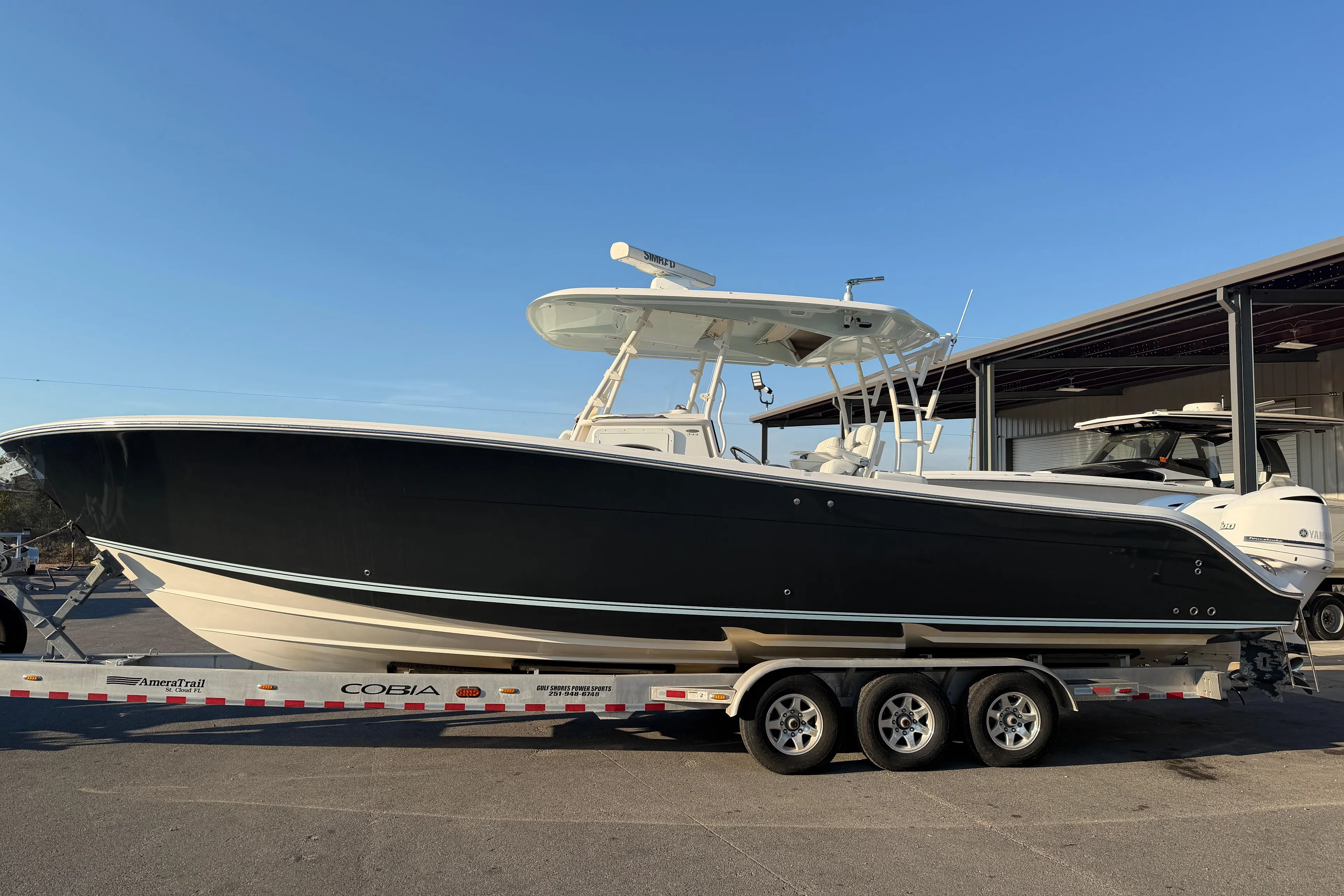 2015 Cobia 344 Center Console boat on trailer under clear blue sky.
