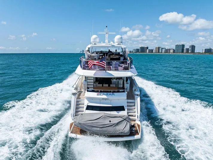 Sea Zar Yacht Photos Pics 2019 Sunseeker 86 Yacht cruising on blue ocean near city skyline.