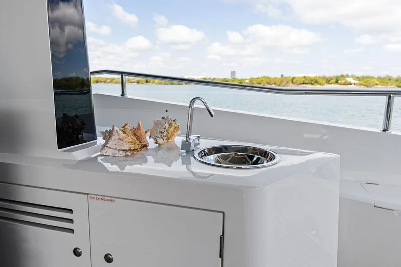 Sea Zar Yacht Photos Pics Luxury Sunseeker 86 Yacht 2019 with outdoor sink and seashells, overlooking serene waters.