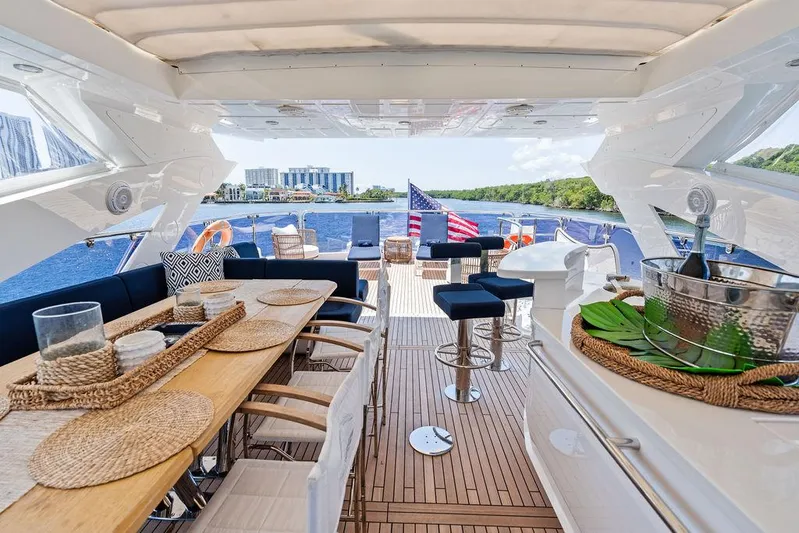Sea Zar Yacht Photos Pics Luxurious 2019 Sunseeker 86 Yacht deck with elegant dining area and scenic waterfront view.