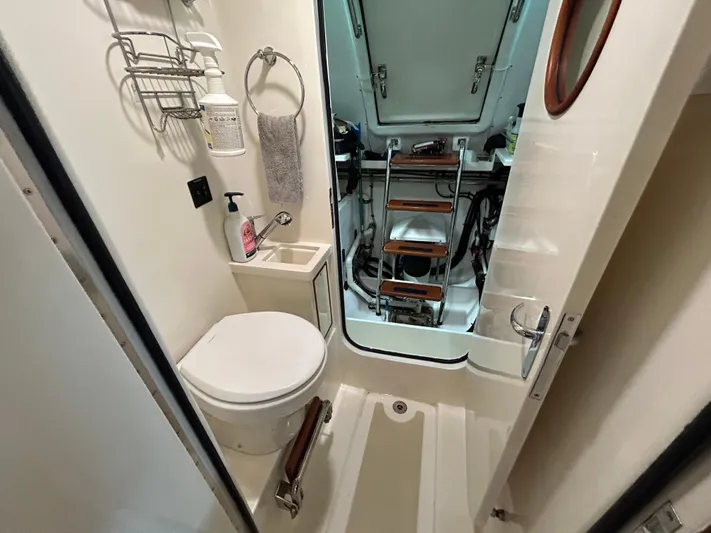 Novia II Yacht Photos Pics Compact bathroom in 2020 Marlow 66E yacht with toilet, sink, and ladder access.