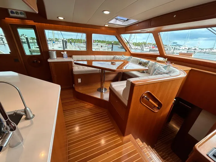 Novia II Yacht Photos Pics Luxurious interior of 2020 Marlow 66E yacht with wood finish and marina view.