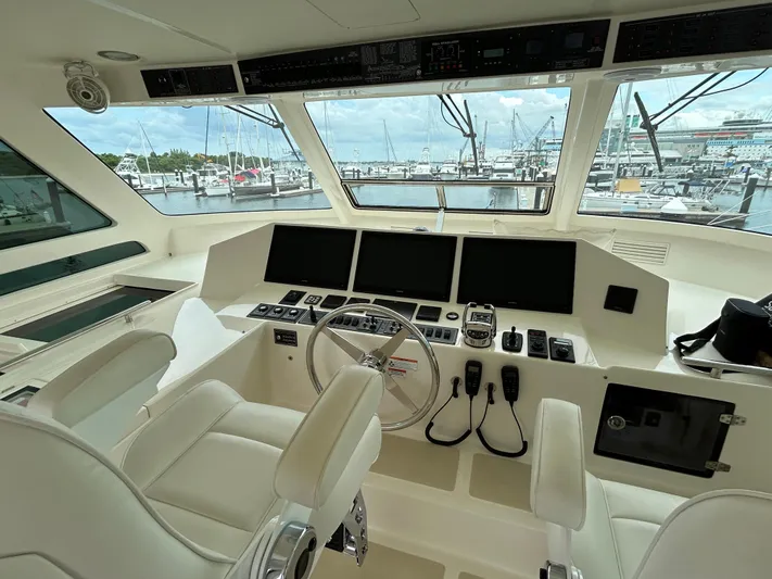 Novia II Yacht Photos Pics Cockpit of 2020 Marlow 66E yacht with modern navigation equipment and marina view.