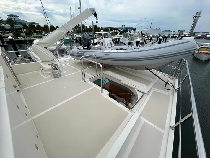 Novia II Yacht Photos Pics 2020 Marlow 66E yacht deck with dinghy and crane at marina.