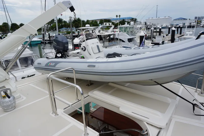 Novia II Yacht Photos Pics A 2020 Marlow 66E yacht with a small boat on deck at a marina.