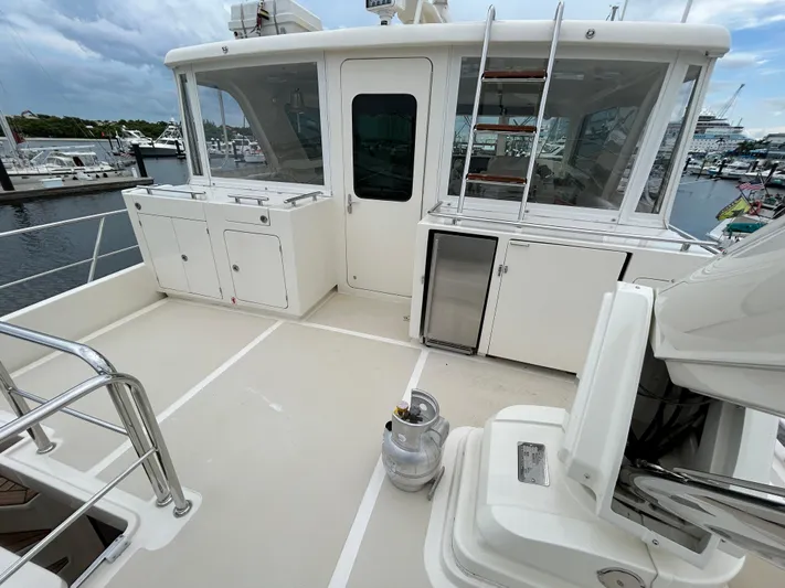 Novia II Yacht Photos Pics 2020 Marlow 66E yacht deck with storage cabinets and marina view.