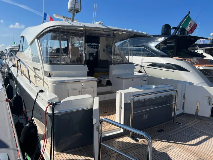 Scorpius Yacht Photos Pics 2022 Riviera 505 SUV yacht docked at marina, showcasing sleek design and spacious deck.