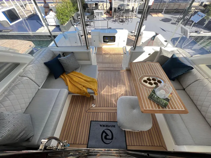 Scorpius Yacht Photos Pics Luxurious 2022 Riviera 505 SUV yacht interior with elegant seating and wooden table.