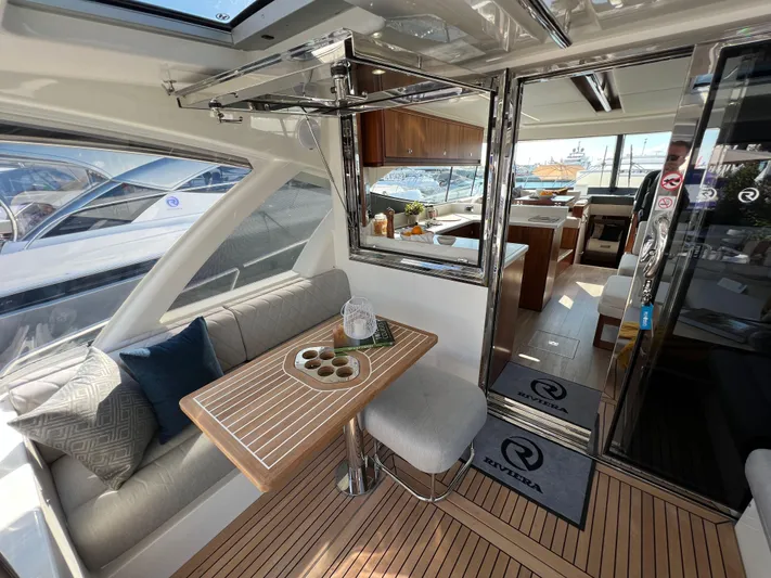 Scorpius Yacht Photos Pics Luxurious interior of 2022 Riviera 505 SUV yacht with elegant seating and dining area.