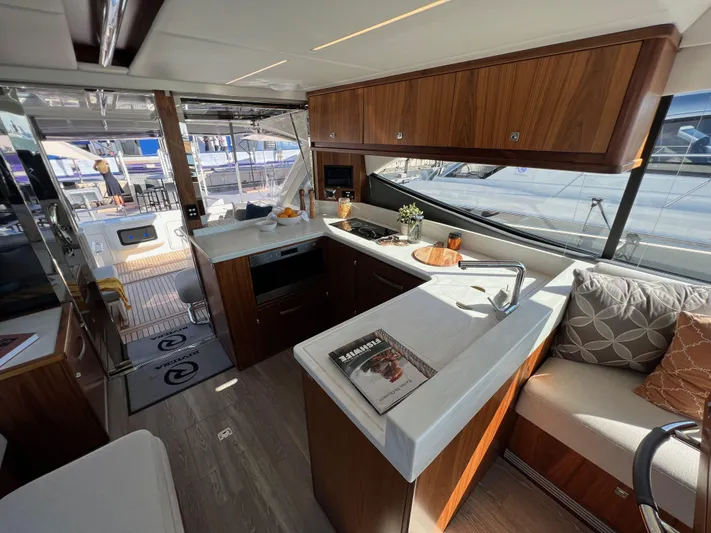 Scorpius Yacht Photos Pics Luxurious 2022 Riviera 505 SUV yacht interior with modern kitchen and seating area.