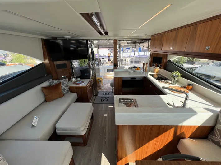 Scorpius Yacht Photos Pics Luxurious interior of 2022 Riviera 505 SUV yacht with modern kitchen and seating area.