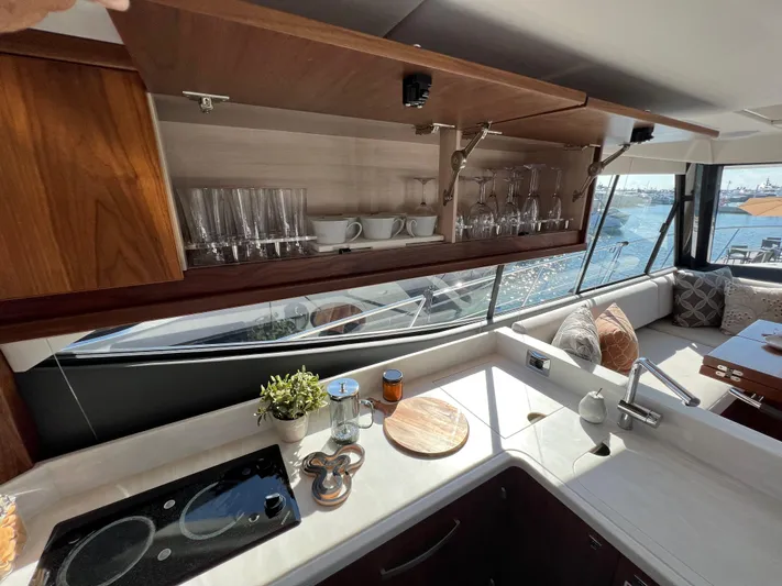Scorpius Yacht Photos Pics Luxurious 2022 Riviera 505 SUV yacht kitchen with elegant cabinetry and ocean view.