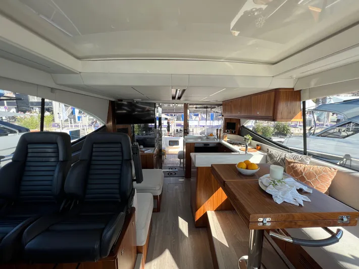 Scorpius Yacht Photos Pics Luxurious interior of 2022 Riviera 505 SUV yacht with modern seating and dining area.