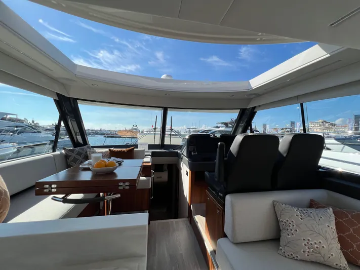 Scorpius Yacht Photos Pics Luxurious interior of 2022 Riviera 505 SUV yacht with panoramic windows and elegant seating.