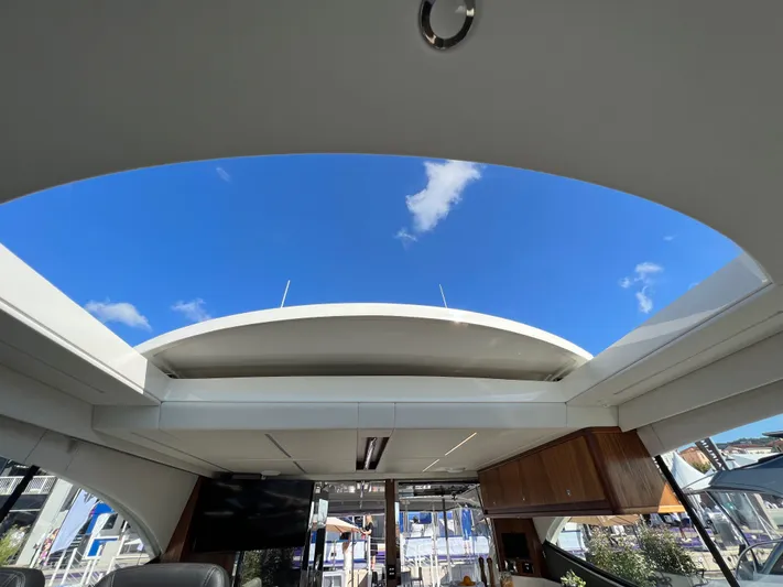 Scorpius Yacht Photos Pics Interior view of 2022 Riviera 505 SUV yacht with open sunroof and blue sky.