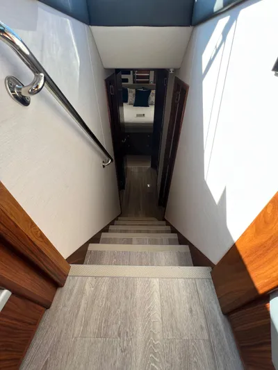 Scorpius Yacht Photos Pics Staircase inside 2022 Riviera 505 SUV yacht, featuring wood accents and modern design.
