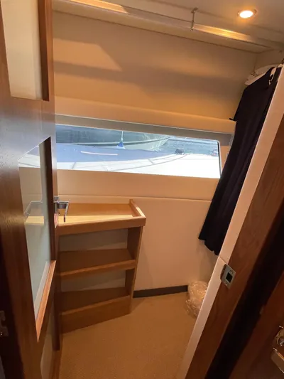 Scorpius Yacht Photos Pics Interior of 2022 Riviera 505 SUV yacht with window view and wooden shelves.