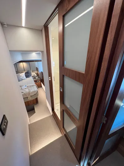 Scorpius Yacht Photos Pics 2022 Riviera 505 SUV interior hallway with modern wood paneling and bedroom view.