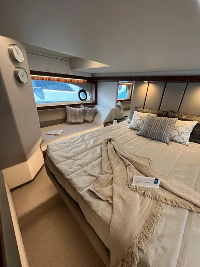 Scorpius Yacht Photos Pics Luxurious bedroom interior of 2022 Riviera 505 SUV yacht with elegant bedding and decor.