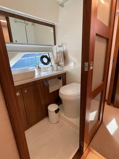 Scorpius Yacht Photos Pics Luxurious bathroom in 2022 Riviera 505 SUV yacht with modern fixtures and wooden accents.