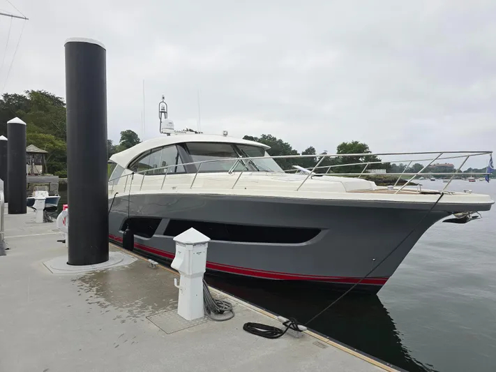 Scorpius Yacht Photos Pics 2022 Riviera 505 SUV yacht docked at marina on a cloudy day.