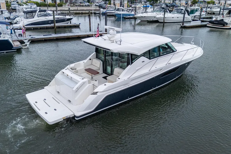  Yacht Photos Pics 2020 Tiara Yachts C44 Coupe in marina, showcasing sleek design and spacious deck.