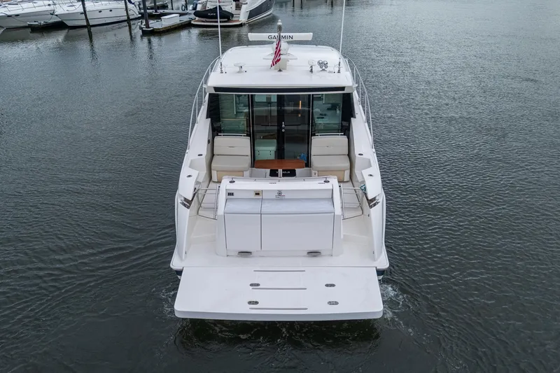  Yacht Photos Pics 2020 Tiara Yachts C44 Coupe docked, rear view showcasing spacious deck and seating area.
