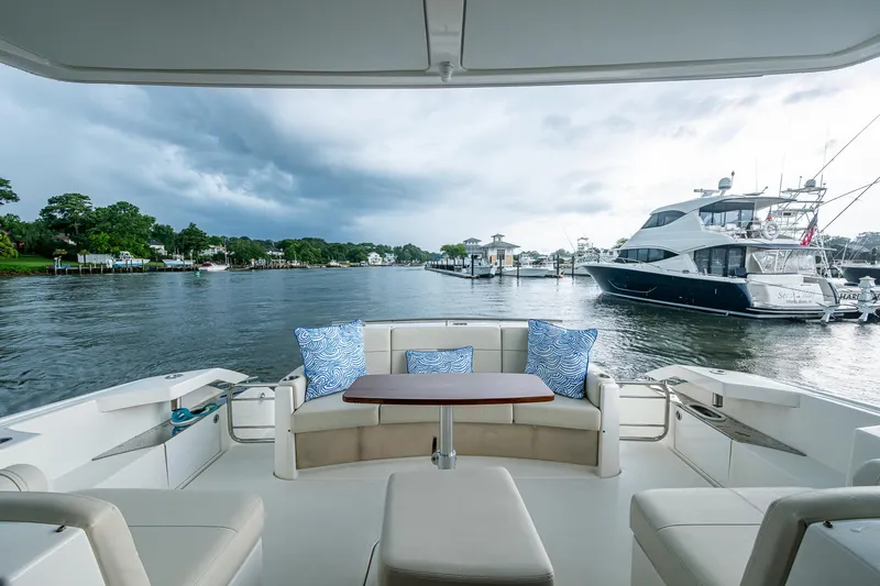  Yacht Photos Pics 2020 Tiara Yachts C44 Coupe interior with scenic marina view, featuring plush seating and cushions.