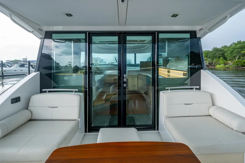  Yacht Photos Pics 2020 Tiara Yachts C44 Coupe interior with sleek seating and glass doors, dockside view.
