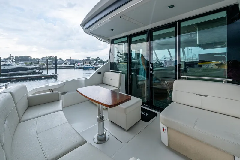  Yacht Photos Pics 2020 Tiara Yachts C44 Coupe with elegant seating and table, docked at marina.