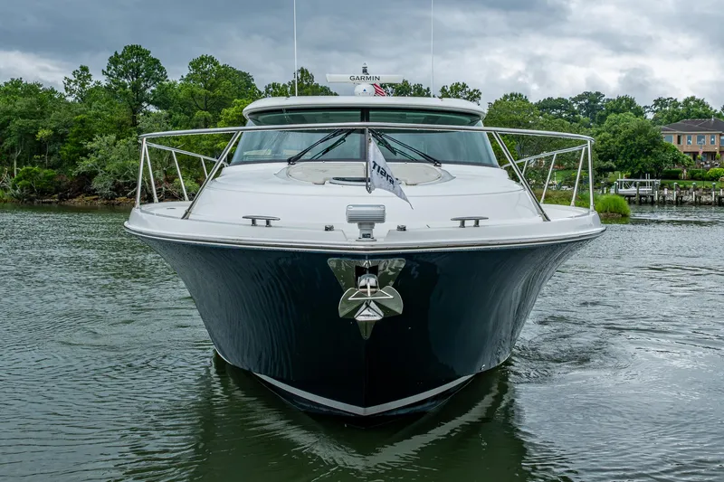 Yacht Photos Pics 2020 Tiara Yachts C44 Coupe on water, front view with lush greenery background.