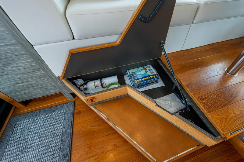  Yacht Photos Pics Open storage compartment in 2020 Tiara Yachts C44 Coupe with books and items inside.