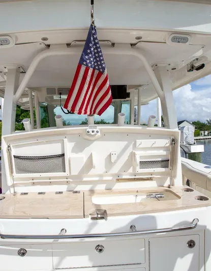 Double Nickel Yacht Photos Pics 2023 Boston Whaler 380 Outrage boat with American flag, featuring a well-equipped cockpit.