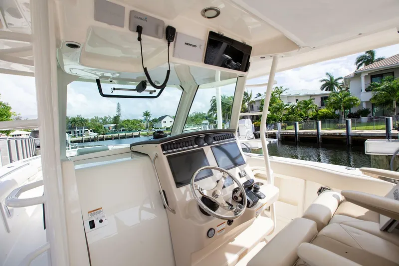 Double Nickel Yacht Photos Pics 2023 Boston Whaler 380 Outrage helm with modern controls and waterfront view.