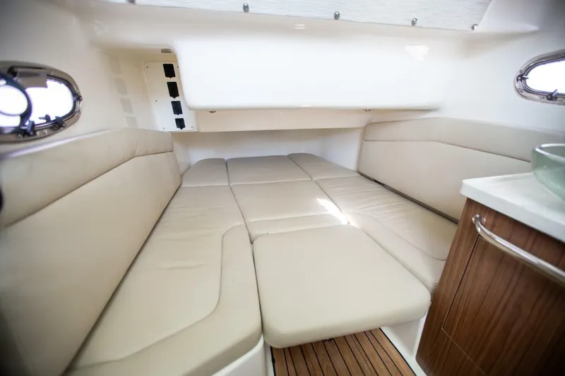 Double Nickel Yacht Photos Pics 2023 Boston Whaler 380 Outrage cabin interior with beige seating and wooden accents.