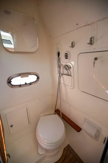 Double Nickel Yacht Photos Pics 2023 Boston Whaler 380 Outrage boat bathroom with toilet, mirror, and showerhead.