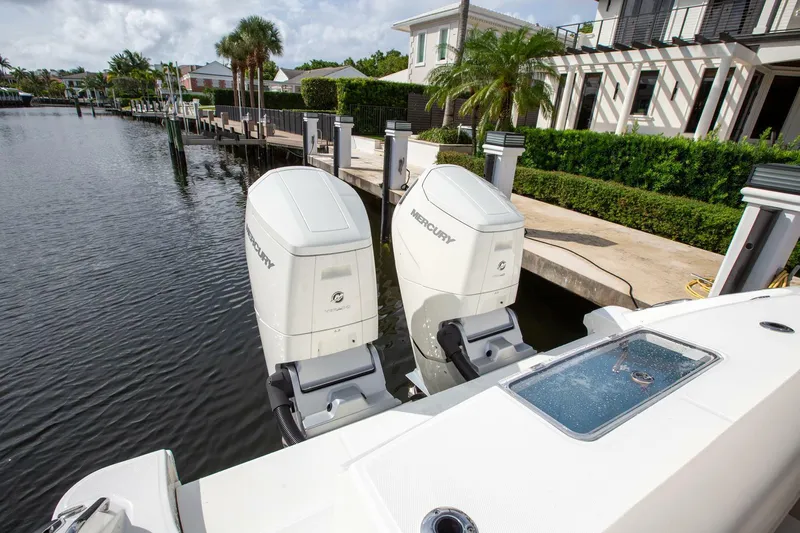 Double Nickel Yacht Photos Pics 2023 Boston Whaler 380 Outrage with dual Mercury outboard engines docked by waterfront homes.