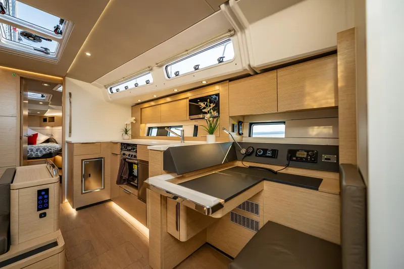 San-197 Yacht Photos Pics Luxurious interior of 2025 Hanse 460 yacht with modern kitchen and cozy seating area.