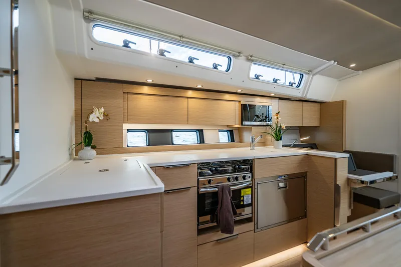 San-197 Yacht Photos Pics Modern kitchen interior of 2025 Hanse 460 yacht with sleek wood cabinetry and appliances.