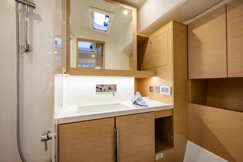 San-197 Yacht Photos Pics Modern bathroom interior of 2025 Hanse 460 yacht with wooden cabinetry and sleek fixtures.