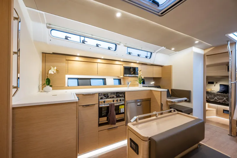 San-197 Yacht Photos Pics Luxurious interior of 2025 Hanse 460 yacht with modern kitchen and cozy seating area.