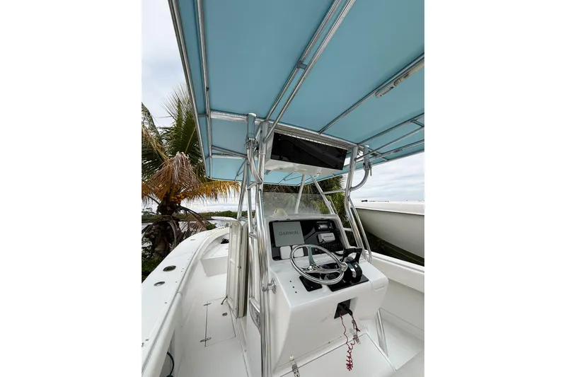  Yacht Photos Pics 2005 Jupiter 31 Center Console boat with blue canopy and steering console.
