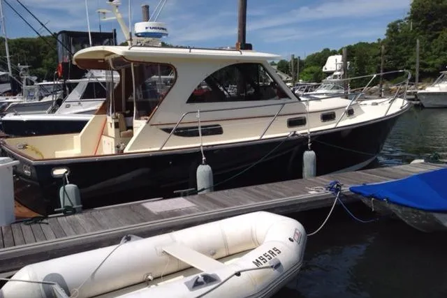 Puffin Yacht Photos Pics 2008 Legacy 32 boat docked at marina with inflatable dinghy nearby.