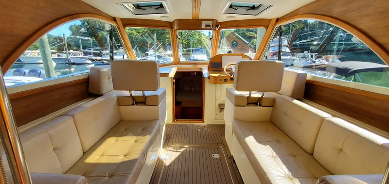 Puffin Yacht Photos Pics Luxurious interior of a 2008 Legacy 32 yacht with plush seating and wooden accents.