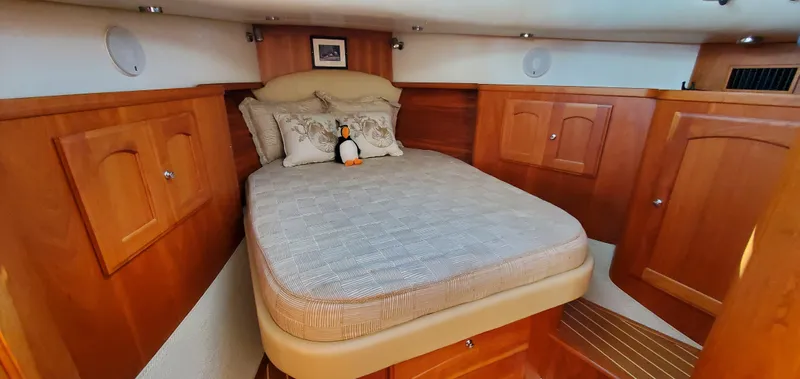 Puffin Yacht Photos Pics Cozy cabin interior of 2008 Legacy 32 boat with wooden finish and plush bedding.