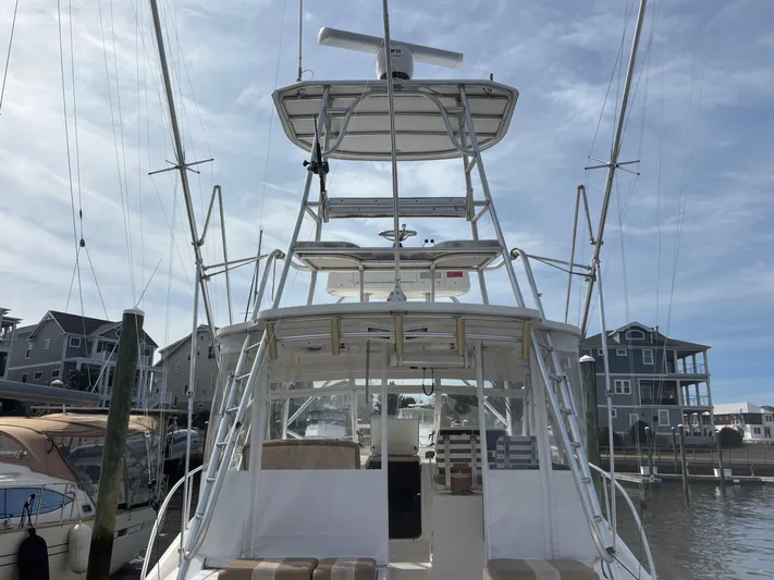 Sawbones Yacht Photos Pics 2011 Luhrs 37 Canyon IPS boat docked at marina, featuring a tall tower and clear skies.