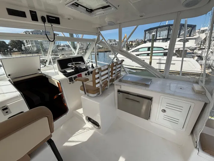 Sawbones Yacht Photos Pics 2011 Luhrs 37 Canyon IPS boat interior with helm, seating, and kitchenette in marina setting.