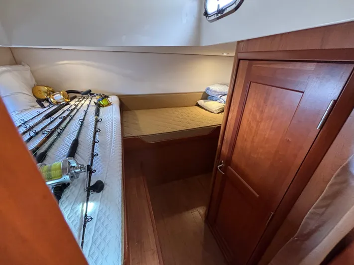 Sawbones Yacht Photos Pics 2011 Luhrs 37 Canyon IPS cabin with fishing rods and cozy bedding.