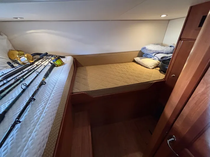 Sawbones Yacht Photos Pics 2011 Luhrs 37 Canyon IPS cabin with fishing rods and cozy bedding.